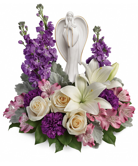 Angel sculpture surrounded by lavender, white and creme flowers and greenery