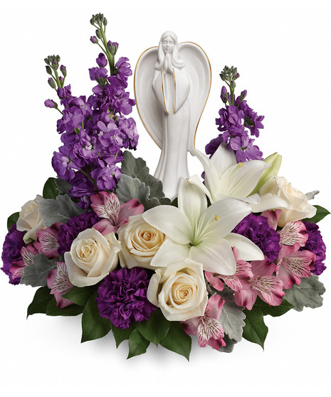 Angel sculpture surrounded by lavender, white and creme flowers and greenery